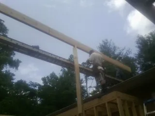 Carpenter setting a ridge beam over a new addition frame — Ice Dam Removal by Roofing Brothers in Gracemont