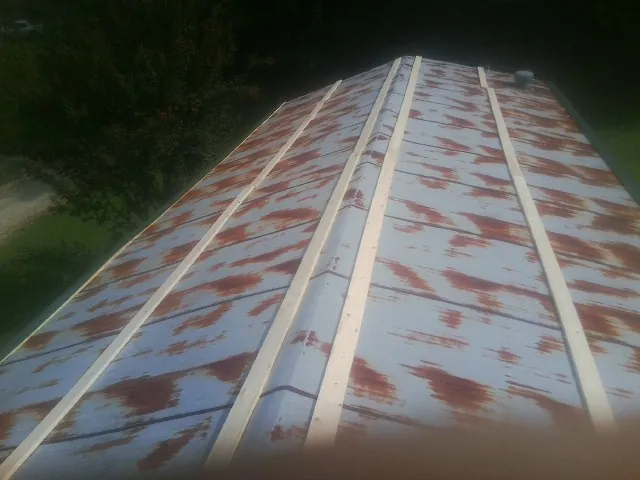 Rusted metal roof panels with new wood purlins before replacement — Storm Damage Roof Repair in Gracemont by Roofing Brothers
