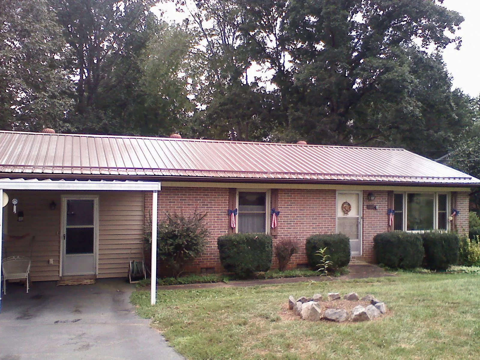 Bronze metal roof and carport on a brick ranch home — Roof Repair work by our crew in Gracemont