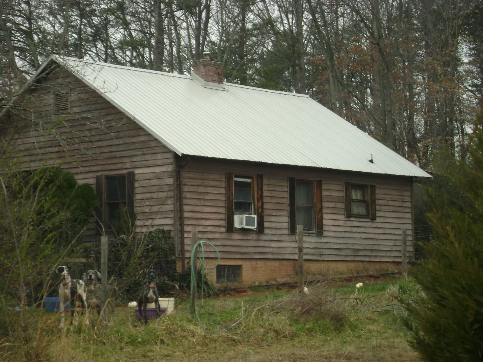 White metal roof on an old wood sided farmhouse, from a Metal Roof Installation job in Gracemont